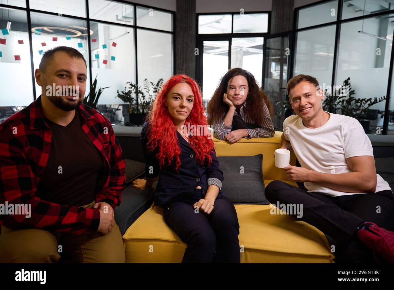 Self confident software developers sitting on cozy couches in lounge zone Stock Photo