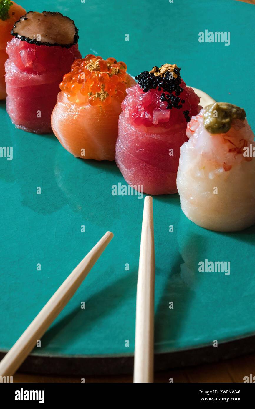 Assorted nigiri sushi, garnished with caviar and gold flakes, presented