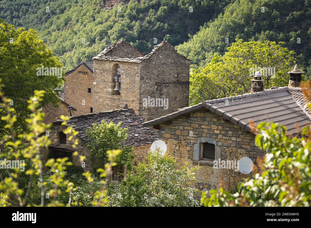 Views of the roofs of a small abandoned village in ruins in the middle of the mountain and a bell tower Stock Photo