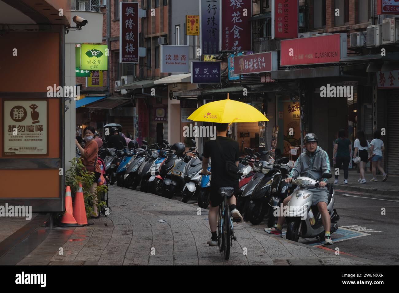 Taipei, Taiwan - October 1, 2023: Busy, colourful urban people and street scenes in the bustling Tamsui District, on a rainly day in Taipei, Taiwan. Stock Photo