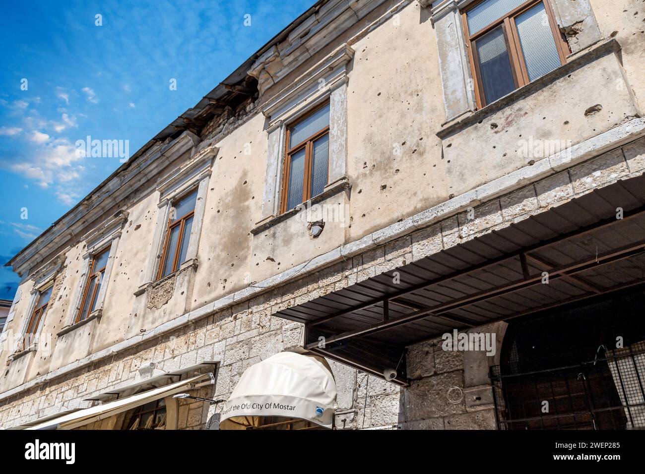 MOSTAR, BOSNIA AND HERZEGOVINA - AUGUST 17, 2022: Bullet holes in a house facade of one abandoned building, caused by gunfire during Bosnian War (1992 Stock Photo