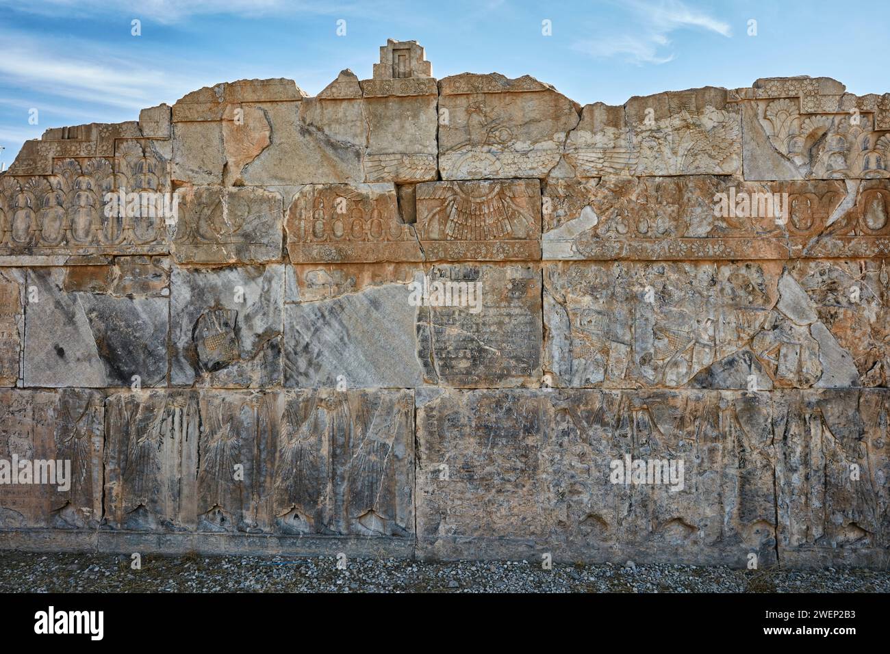 Badly damaged reliefs on a platform of a ruined building in Persepolis, capital of the Achaemenid Empire (550–330 BC), Iran. Stock Photo