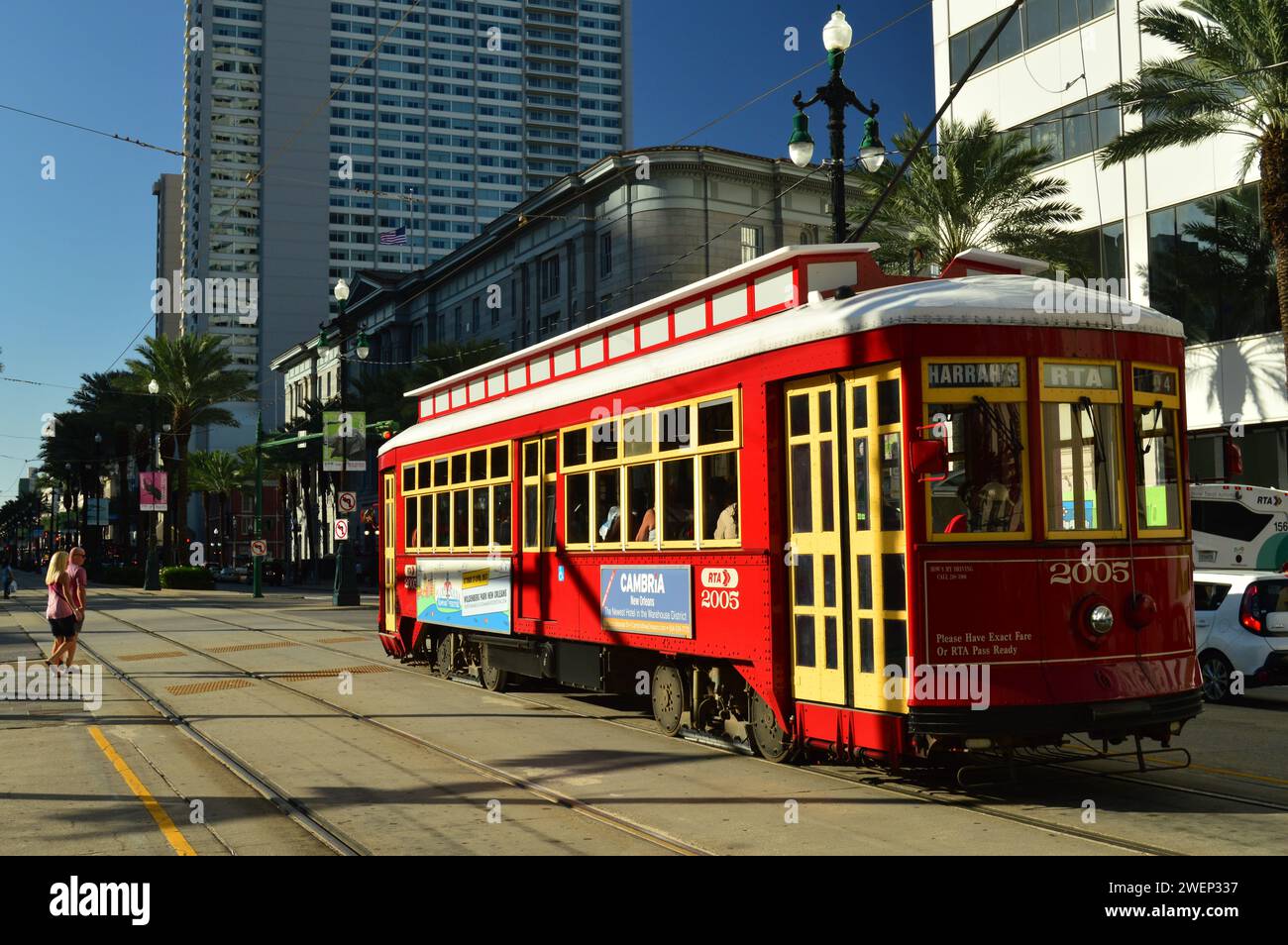 A classic and historic red trolley streetcar glides through the downtown business district of New Orleans Stock Photo