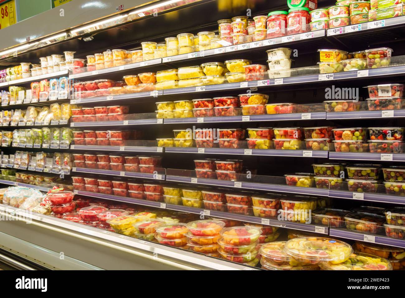 Supermarket grocery store display shelves of packaged sliced and diced fruits and vegetables Stock Photo