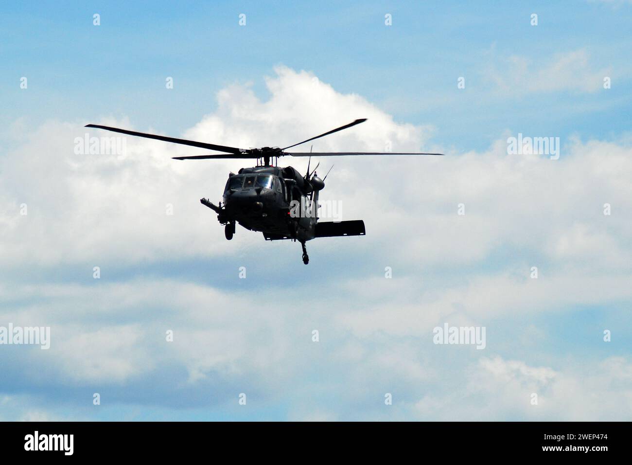 A black hawk military helicopter flies through the sky while on maneuver Stock Photo