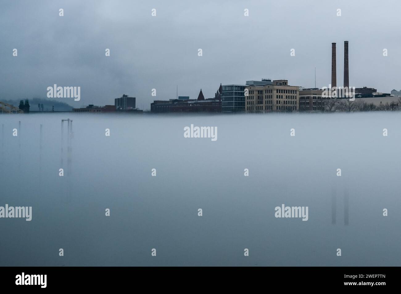 Morning fog on the Allegheny River. The Heinz smokestacks are visible in the background. Stock Photo
