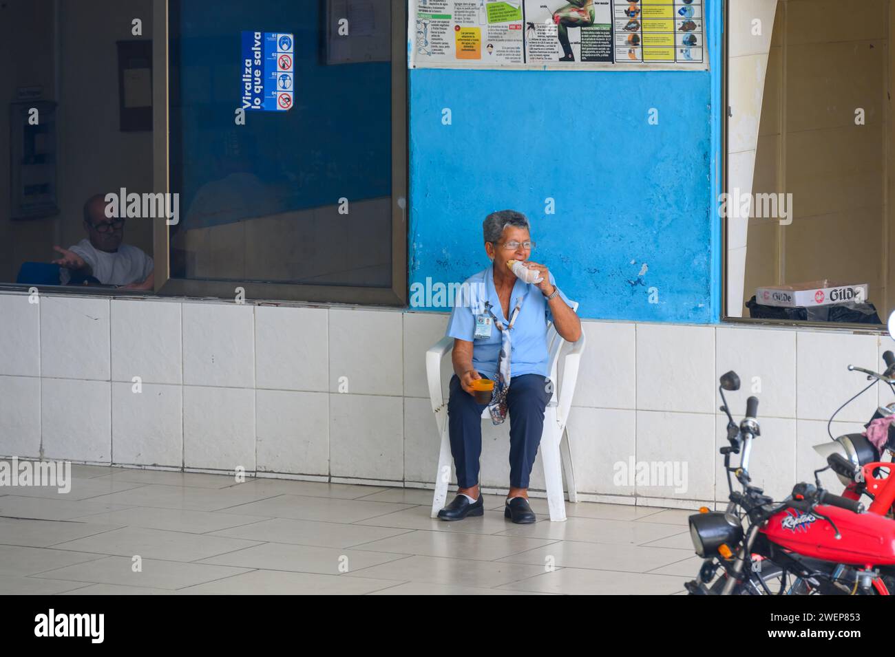 senior woman employee eating snack in inter-provincial bus station, santa clara city, cuba, 2024 Stock Photo