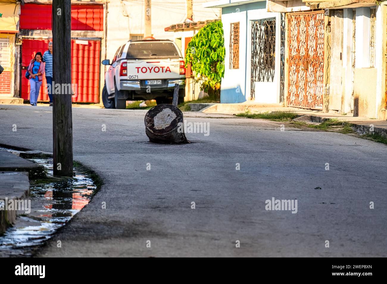Rustic marker signaling a dangerous hole in the street, Santa Clara, Cuba Stock Photo