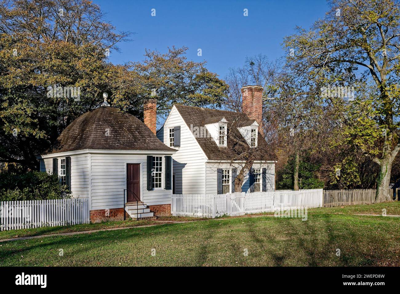 2 small houses, close together, white, shutters, chimneys, dormer