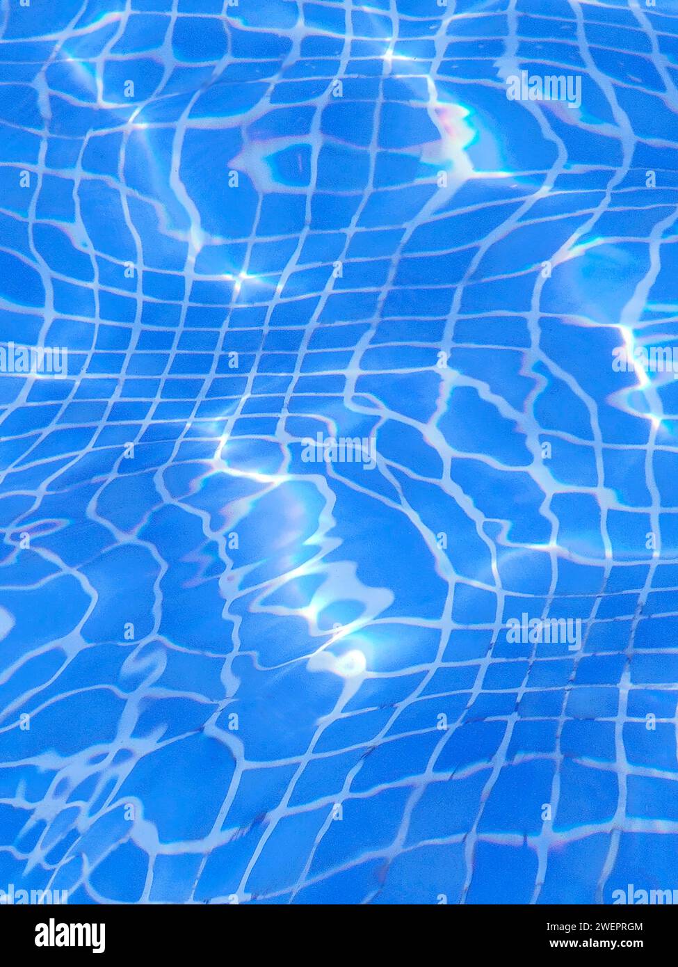 A swimming pool with rays of sunlight reflecting on the water surface ...