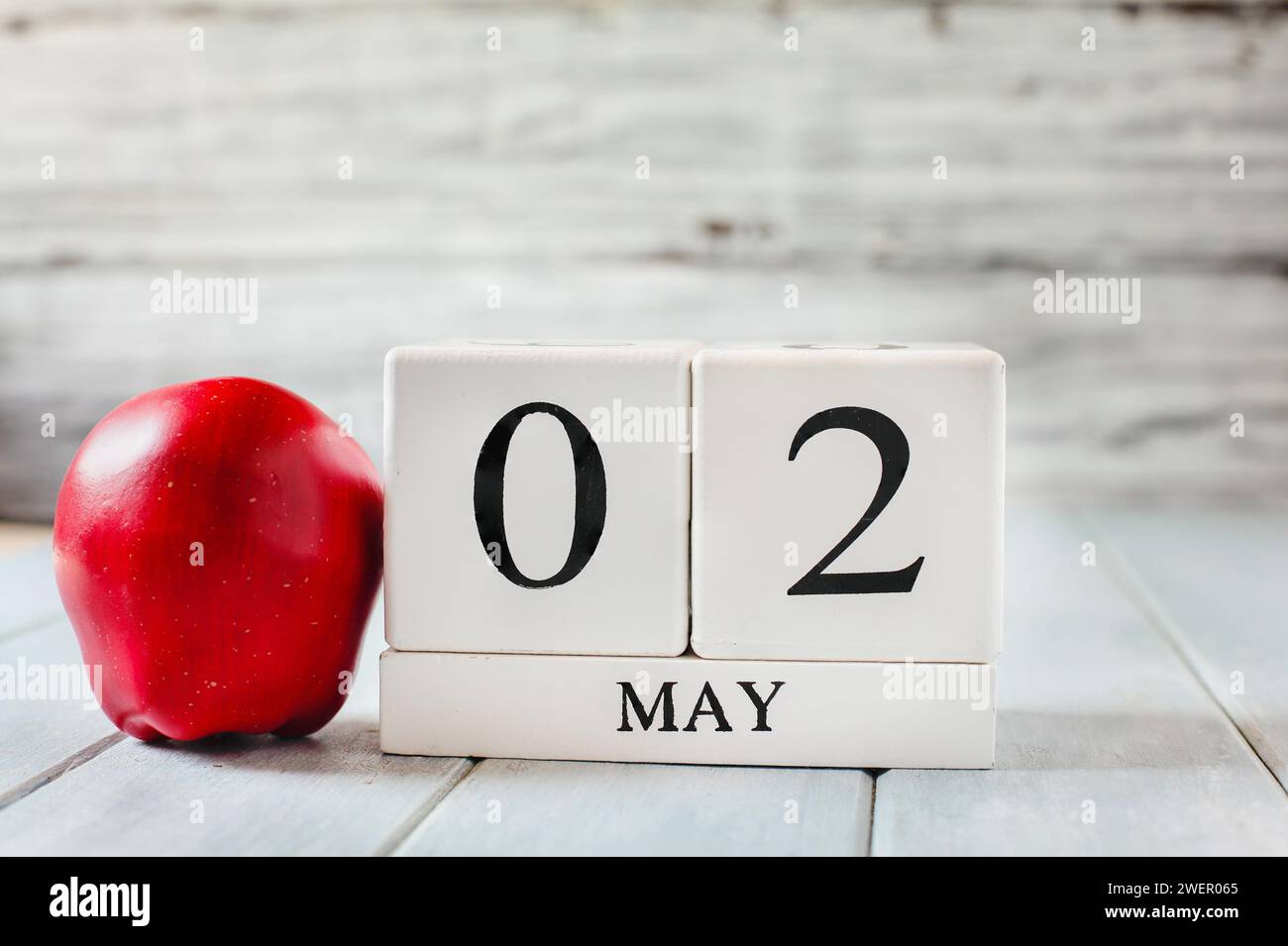 White wood calendar blocks with the date May 2nd and a red apple for National Teacher Appreciation Day. Stock Photo