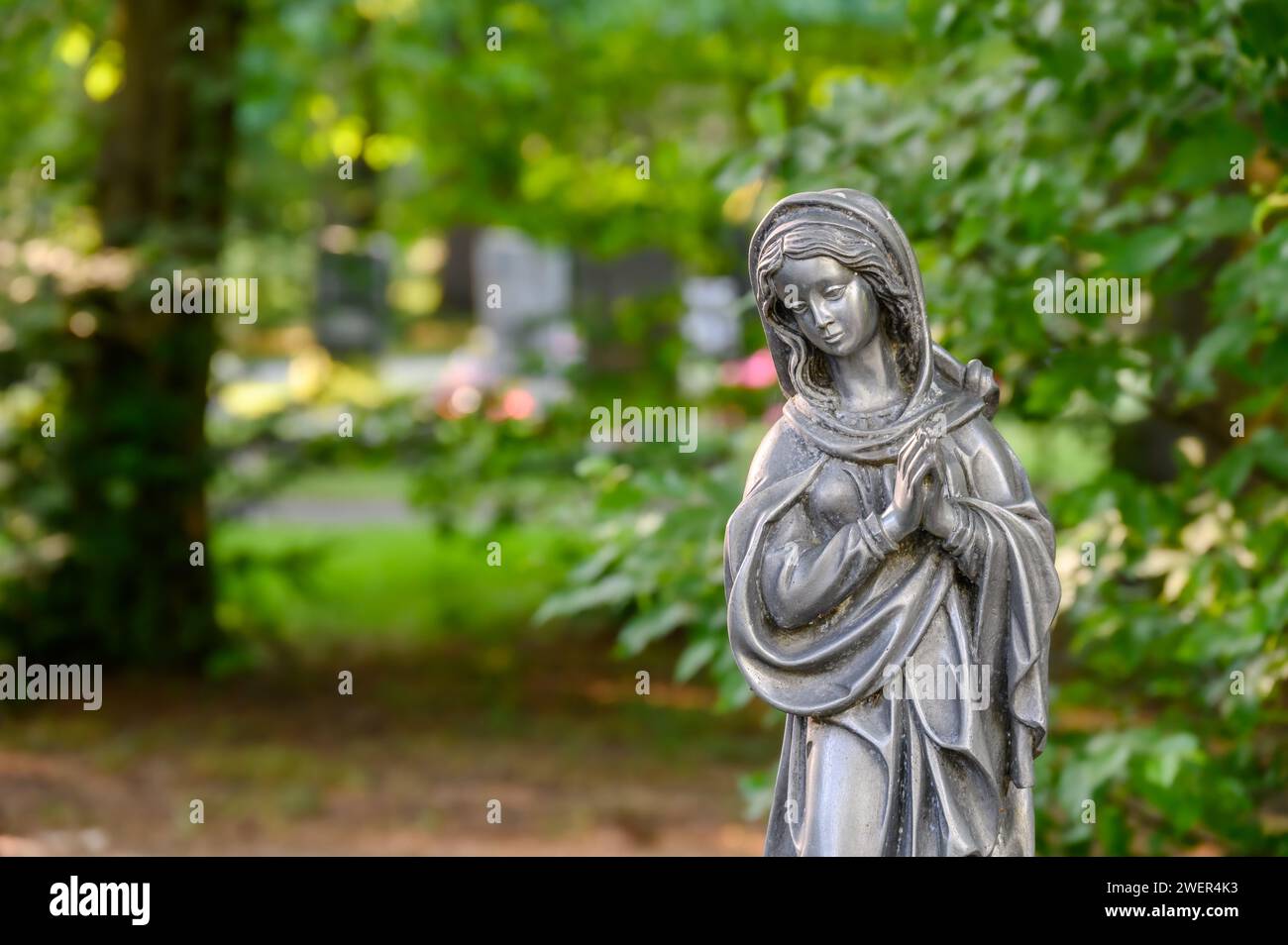 Praying Madonna figure at the cemetery Stock Photo