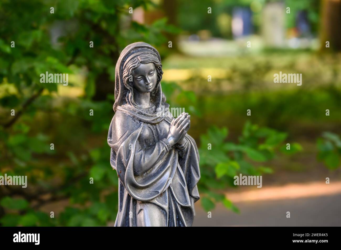 Praying Madonna figure at the cemetery Stock Photo
