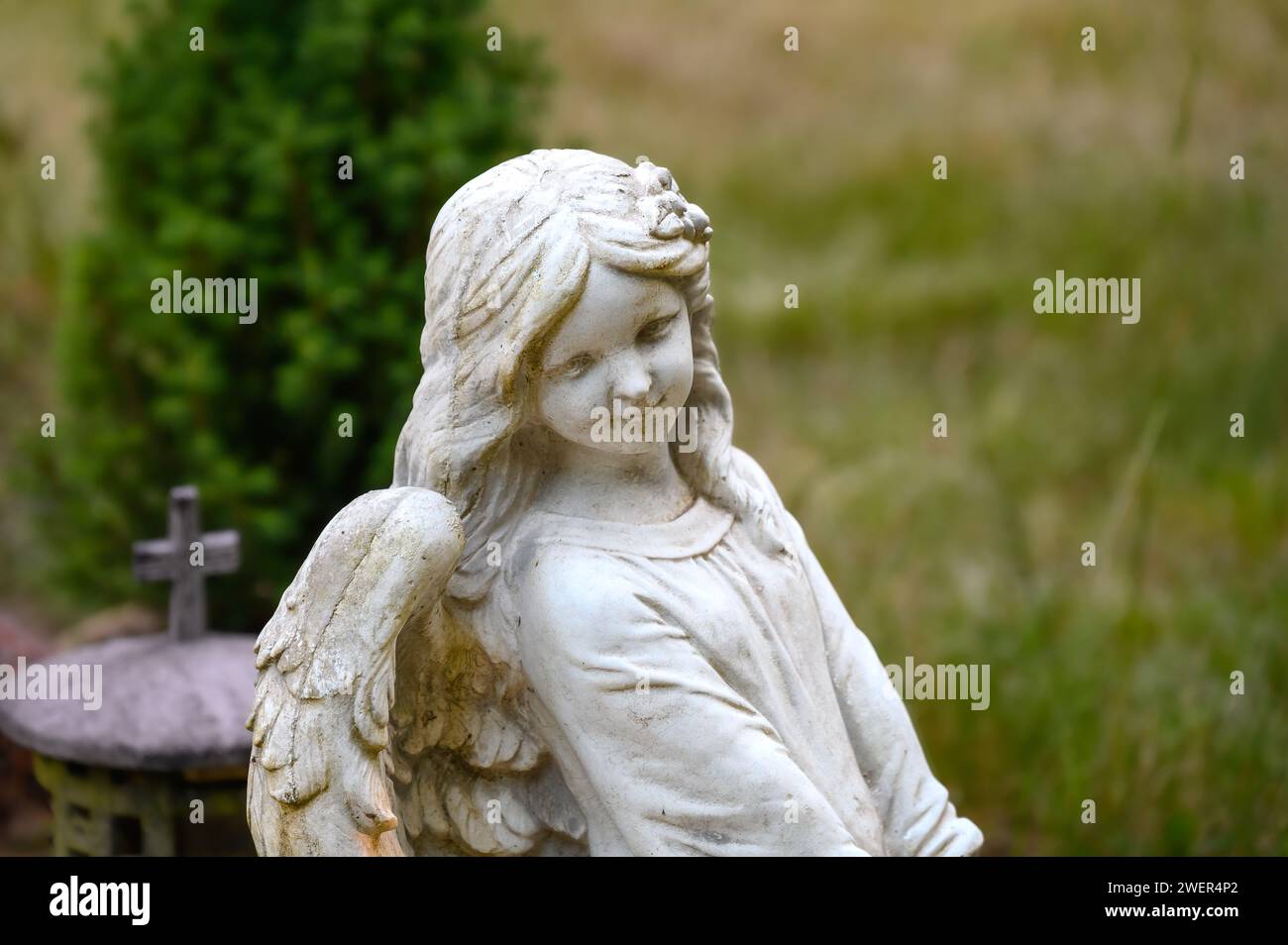 Childlike angel statue at a gravesite Stock Photo