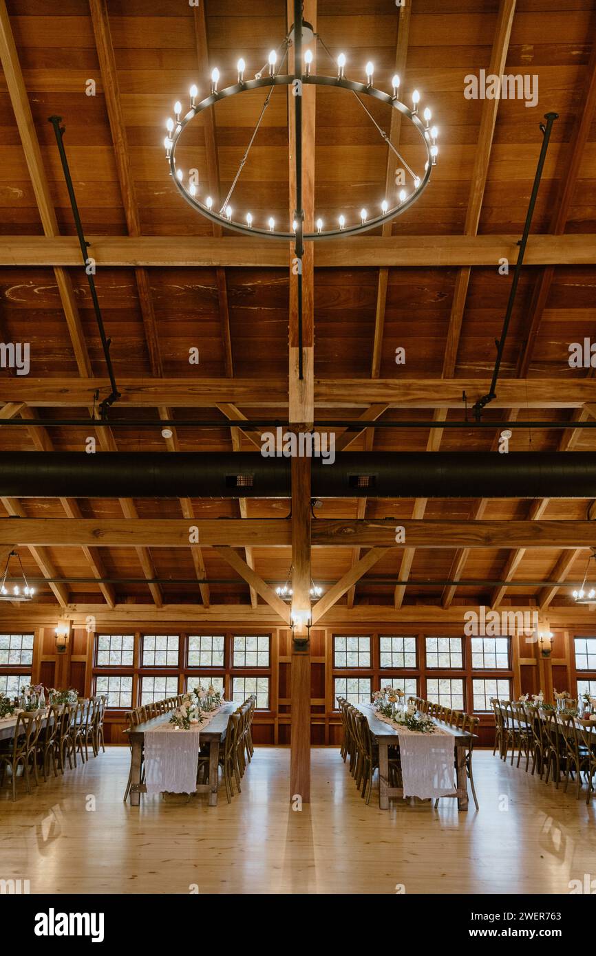 A light fixture hanging from rafter ceiling in rustic barn reception ...