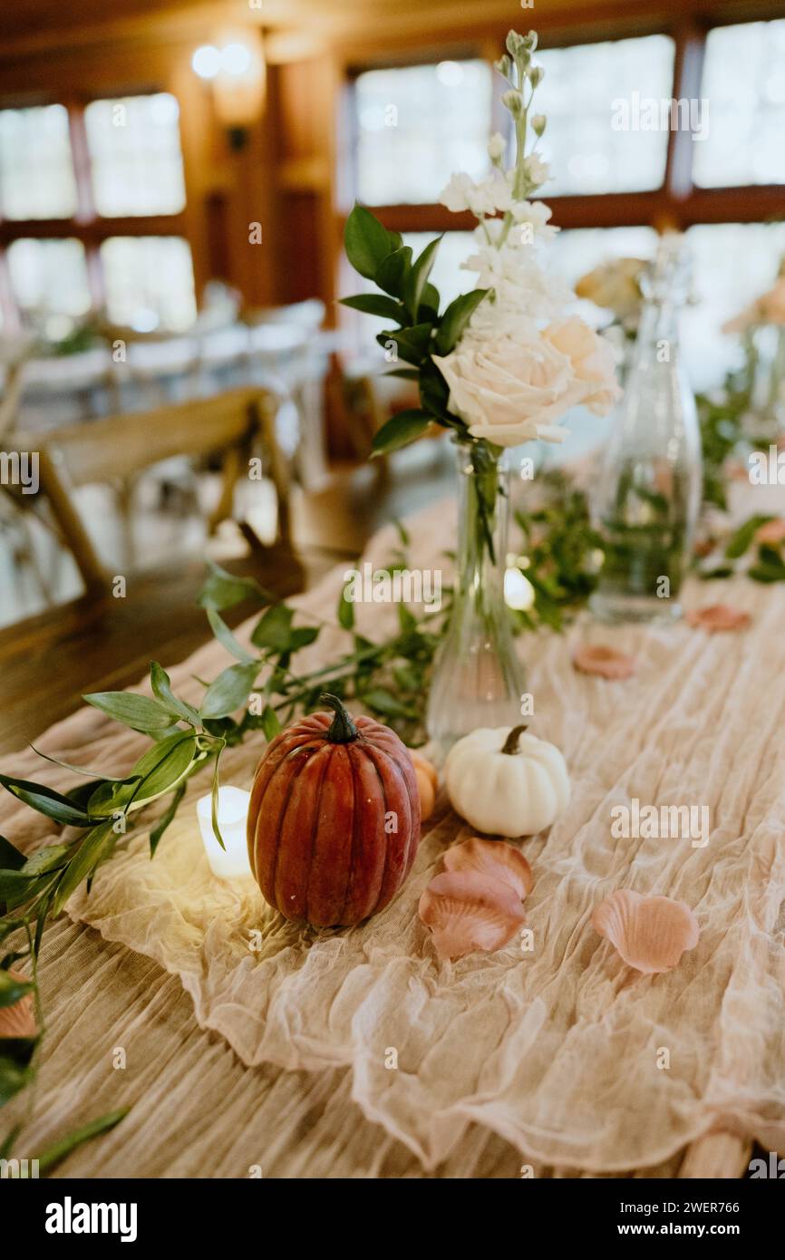 A fall tablescape decor adorned with white flowers and pumpkins Stock Photo