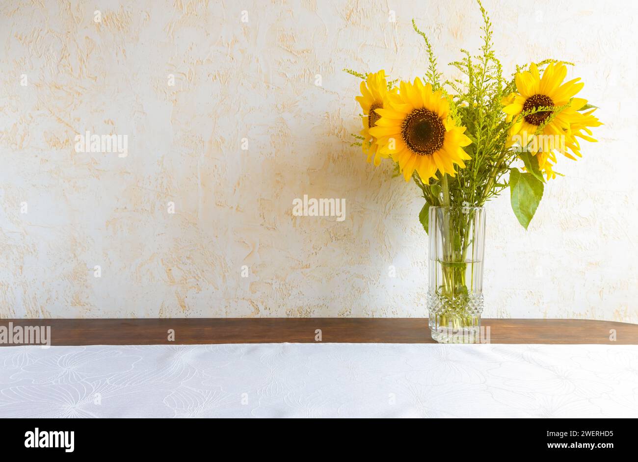 A bouquet of beautiful sunflowers in a glass vase on the table. Floral ...