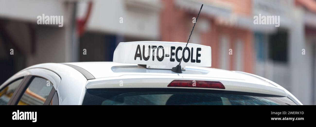 White car roof sign with written in it in French 'Auto-Ecole', meaning in English 'Driving school'. Stock Photo