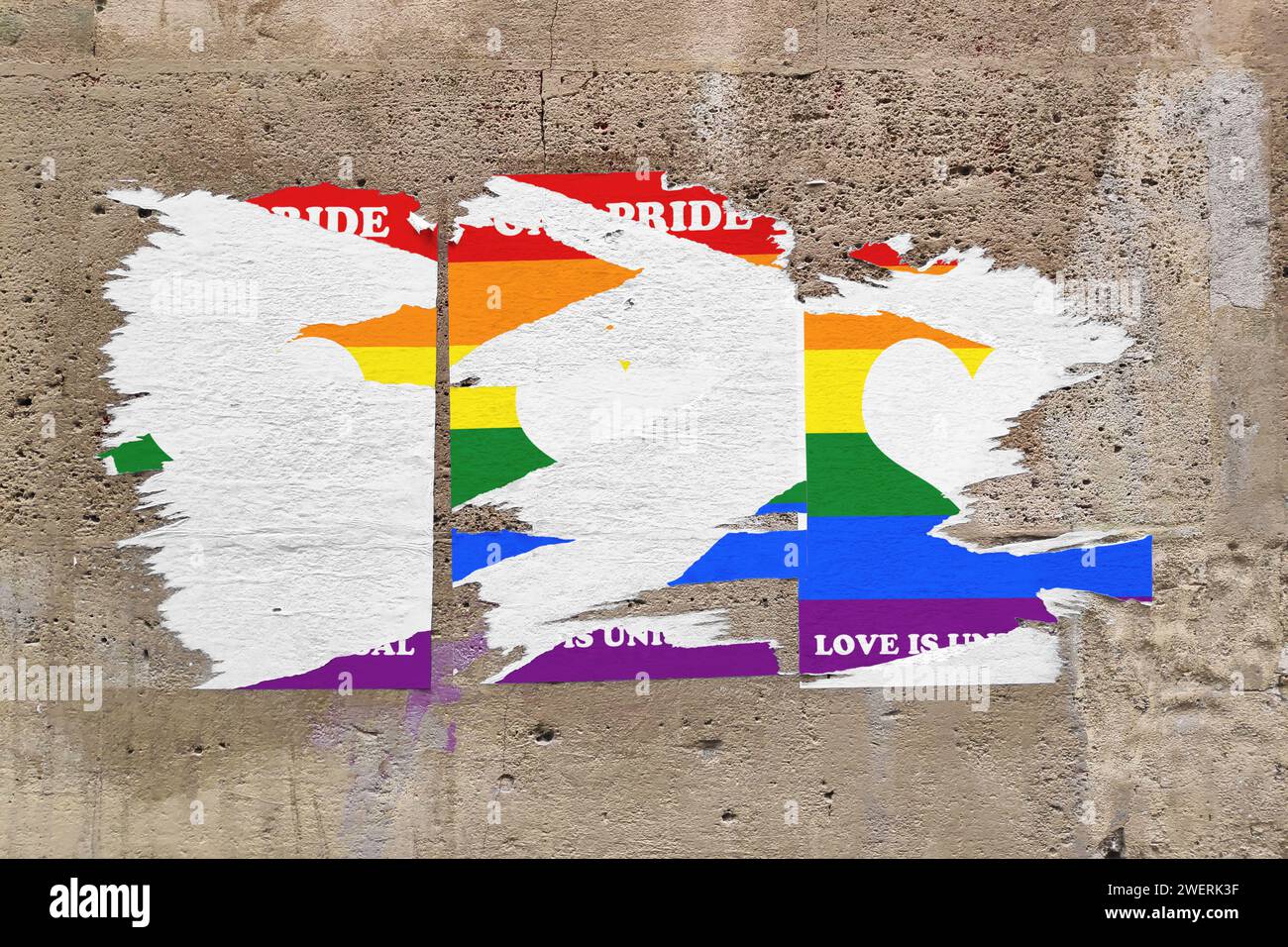 Full-frame weathered limestone wall with three torn rainbow posters in the middle depicting an heart sign with the message "Gay pride - Love is univer Stock Photo