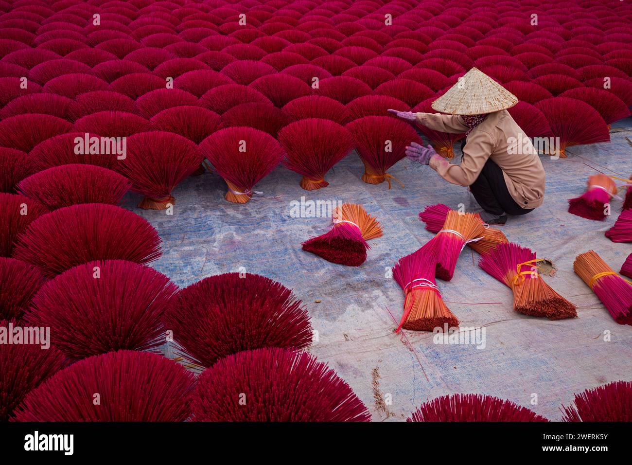Aerial view of incense workers sits surrounded by incense stick, where the sticks have been traditionally made for hundreds of years in Hanoi, Vietnam Stock Photo