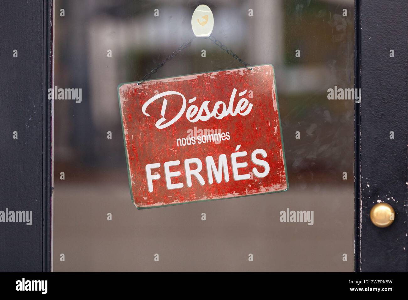 Red open sign with written in it in French: 'Désolé, nous sommes fermés', meaning in English 'Sorry, we're closed'. Stock Photo