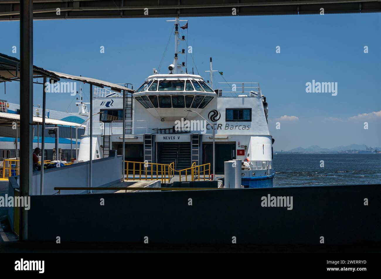 Neves V CCR passenger ferry vessel docked at Arariboia terminal ferry station in Niteroi's Centro district under summer afternoon sunny clear blue sky. Stock Photo