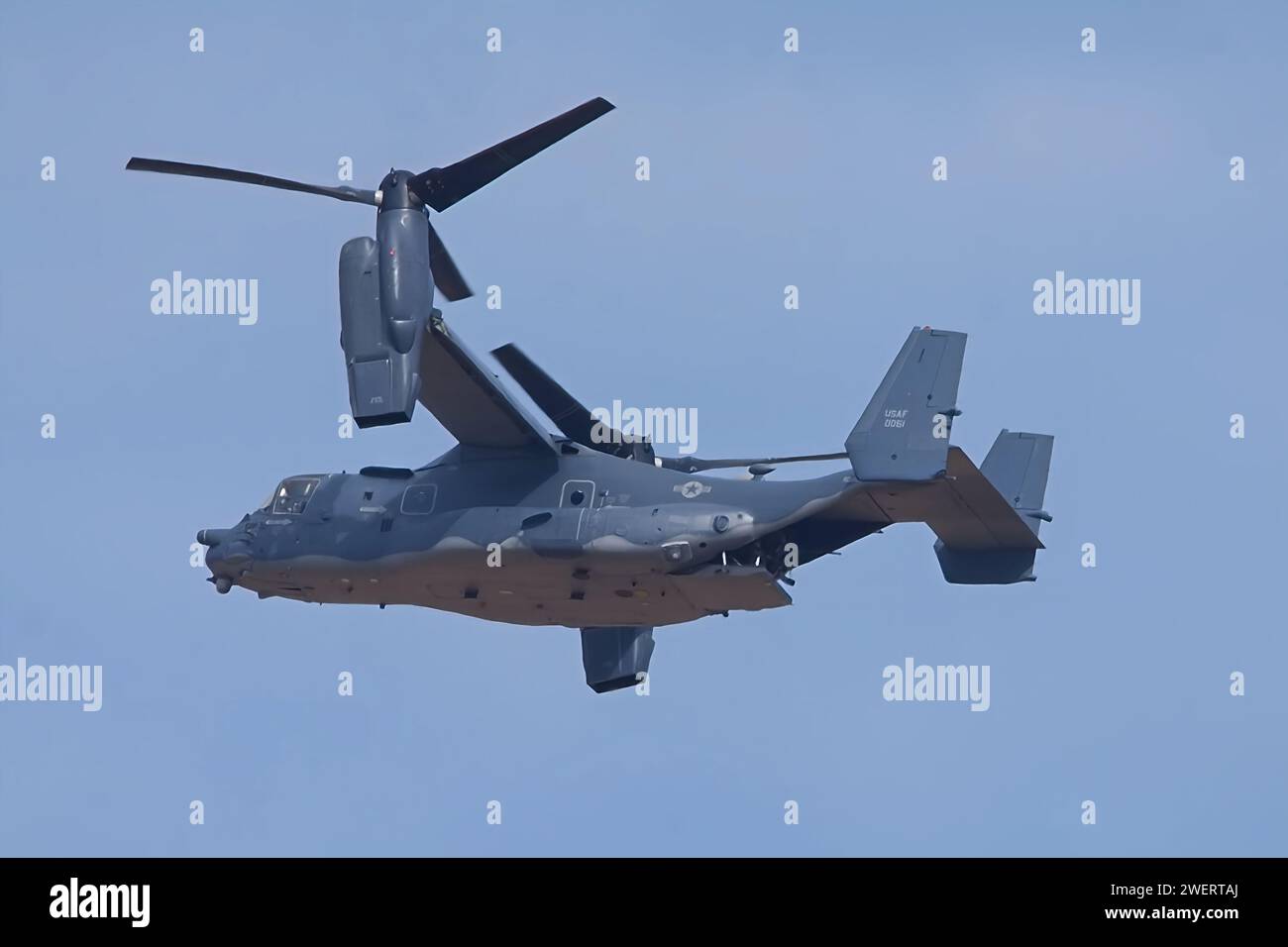 United States Air Force Osprey aircraft in flight over the range with rotors vertical and the rear ramp partially down. Stock Photo