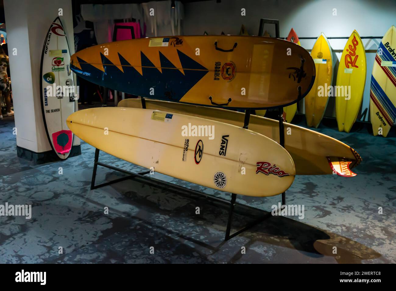 A collection of colorful surfboards on a rack, part of Rico Surf museum exhibition displayed inside AquaRio public marine aquarium in Gamboa district. Stock Photo