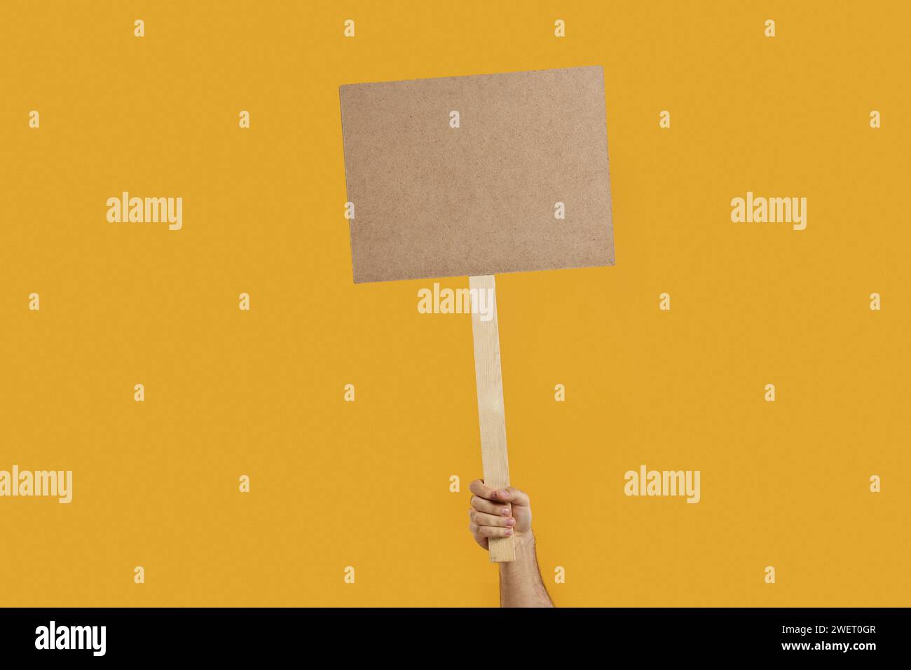 Man holding blank sign on orange background, closeup. Space for text Stock Photo