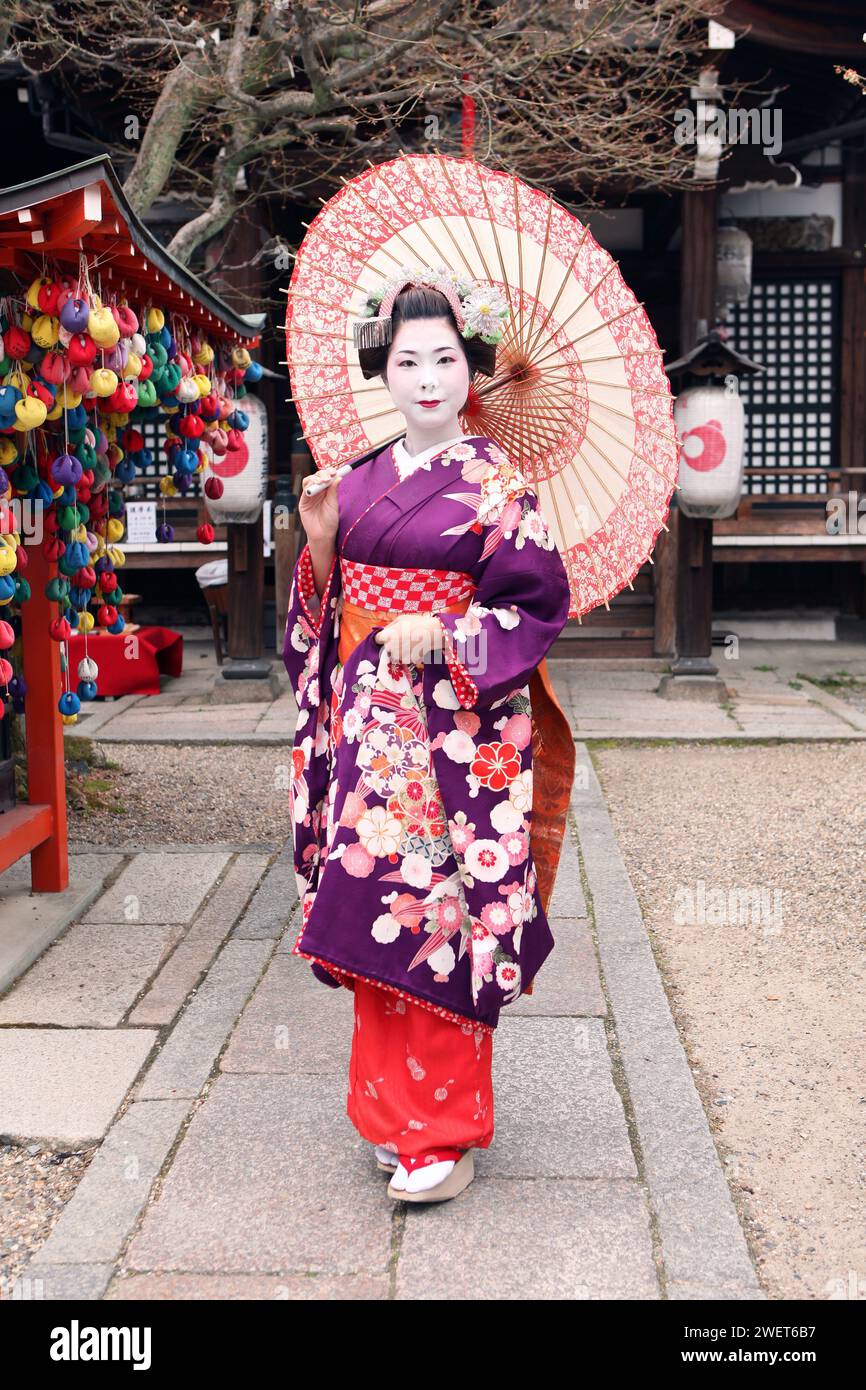 Beautiful Japanese Geisha Maiko in Kyoto, Japan with umbrella Stock Photo