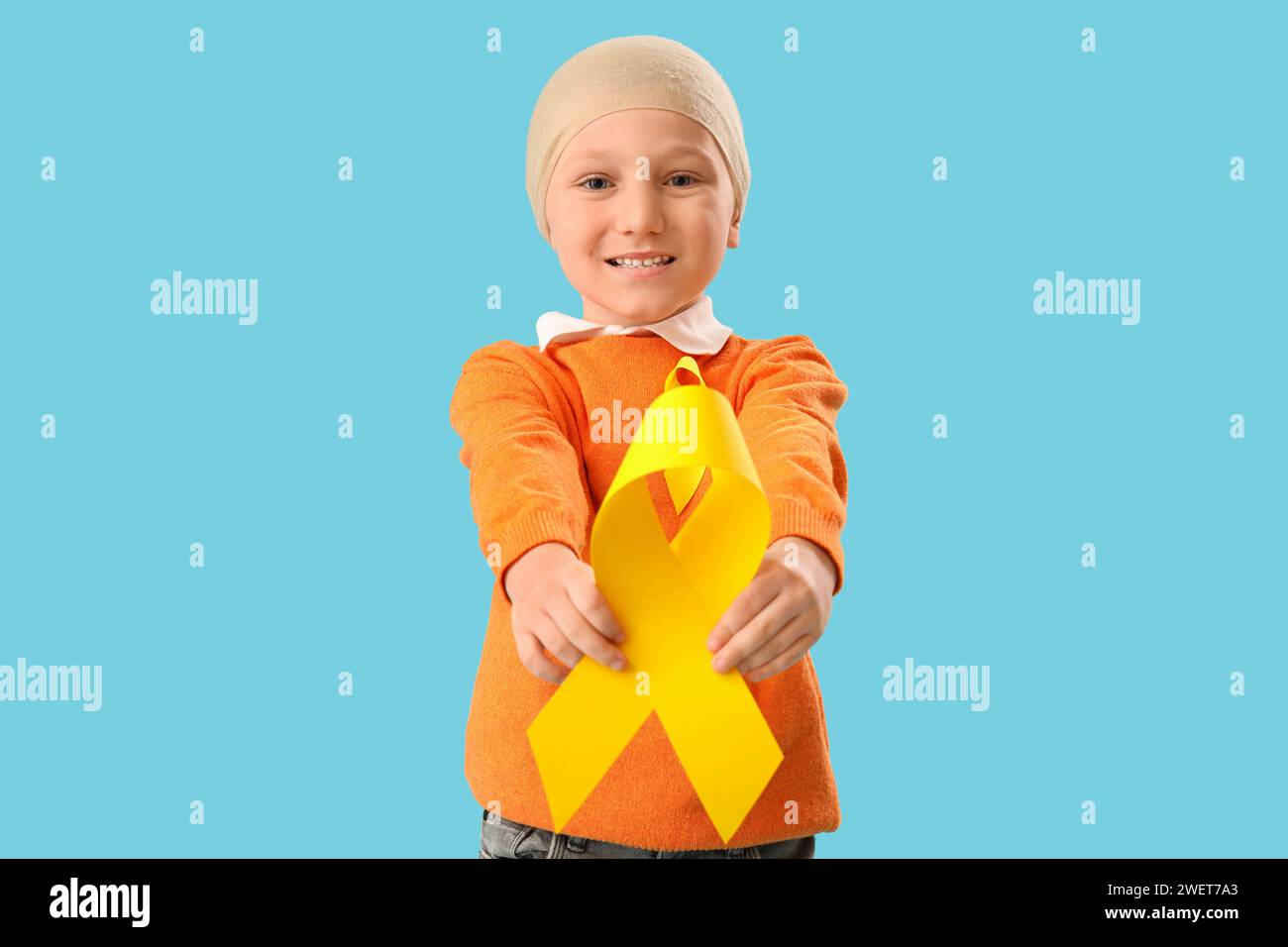 Cute little boy after chemotherapy with yellow ribbon on blue ...