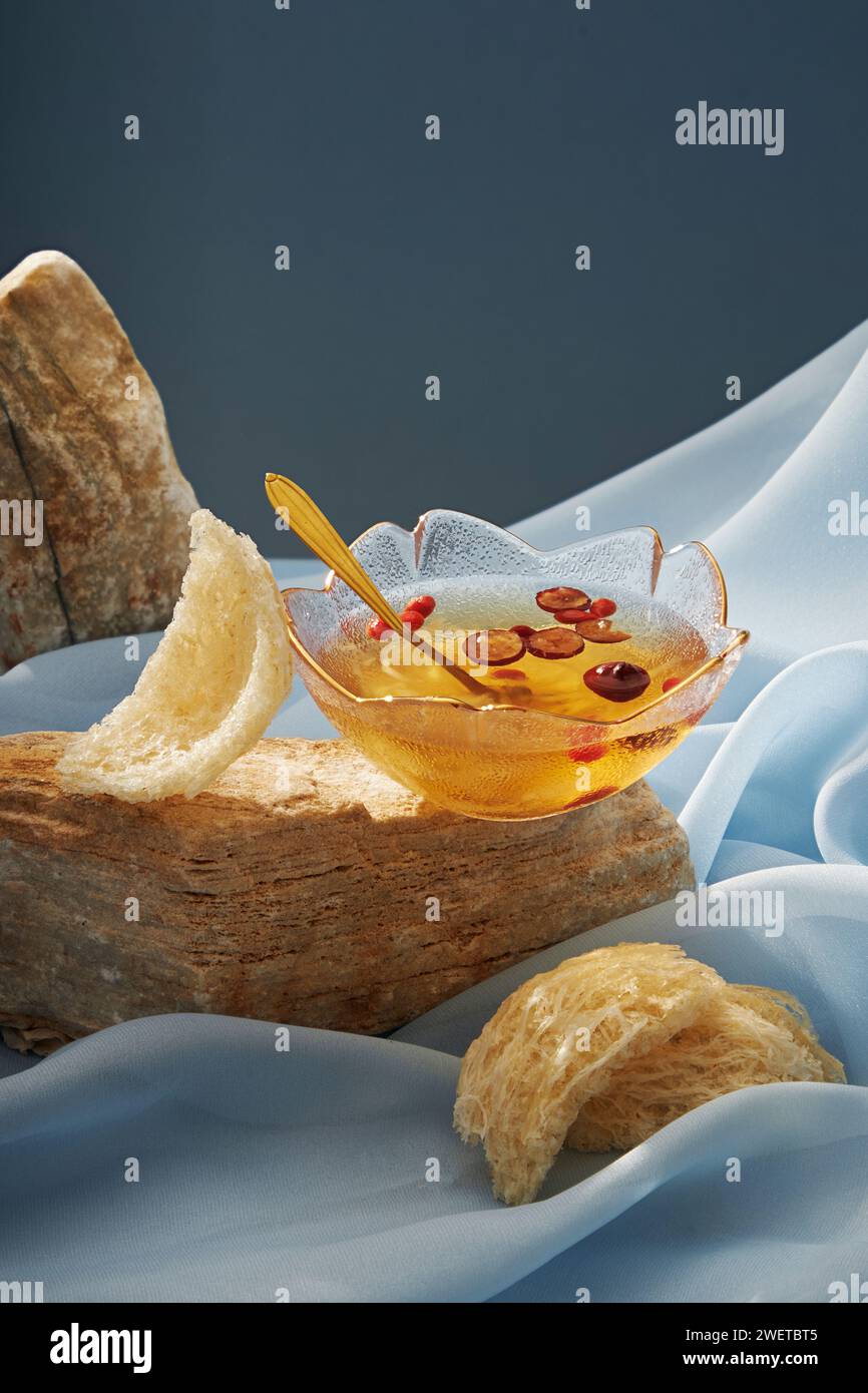 A bowl soup of bird nest distilled with jujube, next to is raw edible bird nest decorated on