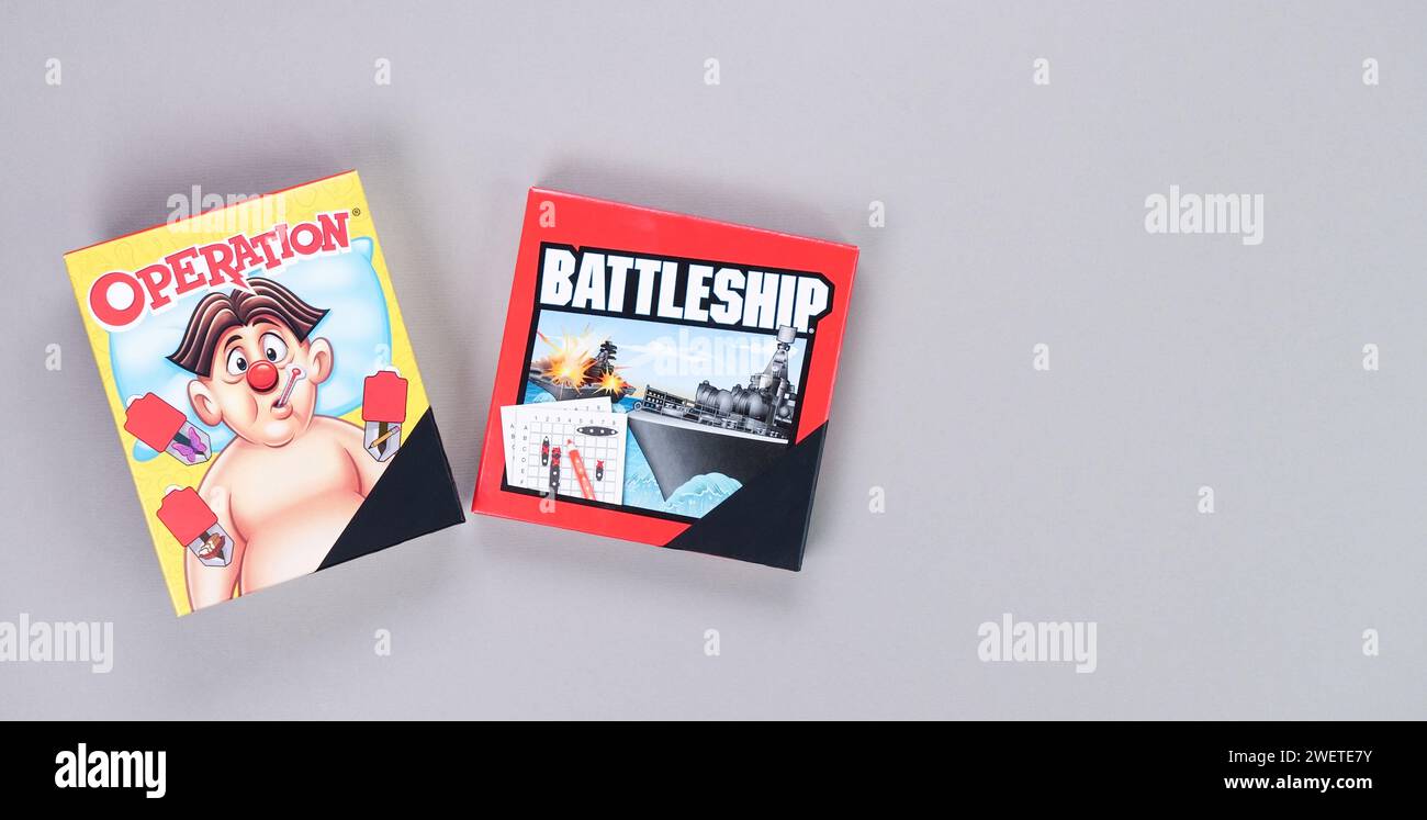 Mini board games on grey background. Fun games to play with kids. Boxes of Operation, Battleship games. Gatineau, QC Canada - 12-23-2022. Stock Photo