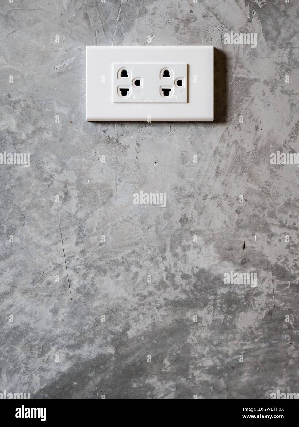 white plug socket on the room wall Stock Photo