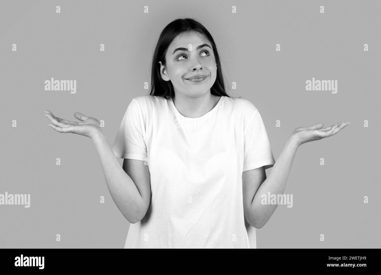 Confused beautiful woman with questioning gesture. Girl shrugging shoulders, doubts. Stock Photo