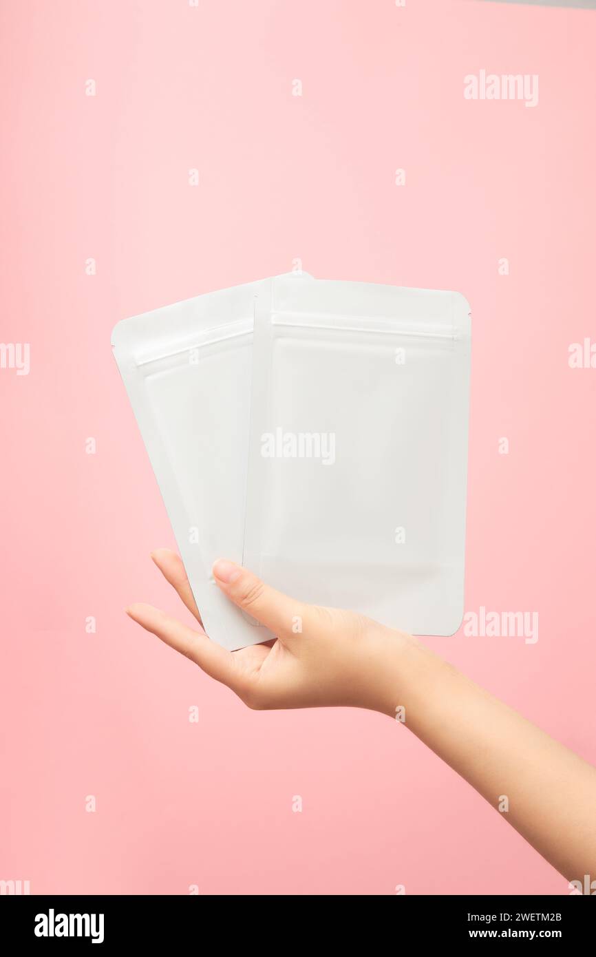 Female hand holding facial sheets mask white blank realistic mockup on