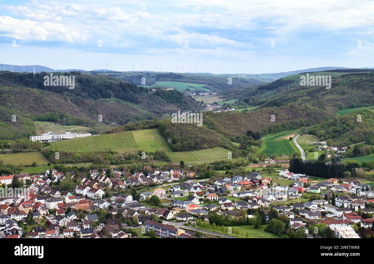 Bad Munster, Germany - May 9, 2021: Green hills and wind turbines behind a small German town on a spring day at Rotenfels. Stock Photo