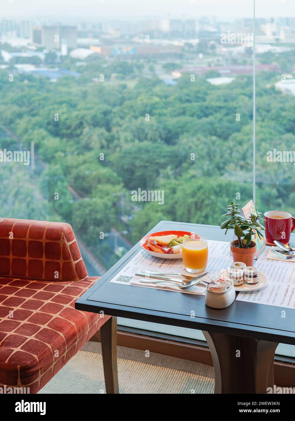 Breakfast at a hi-rise hotel  in Manila, Philippineswith city view blurred in the background. Stock Photo