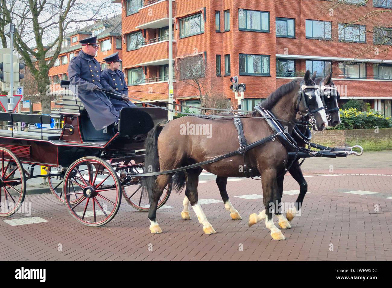 Traditional horse-drawn carriage driven by coachmen in costume in the city of The Hague, Netherlands Stock Photo