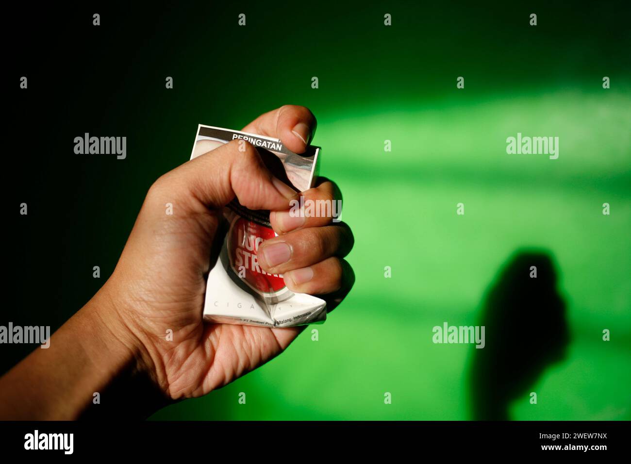 Close up of a hand squeezing an empty pack of Lucky Strike cigarettes Stock Photo