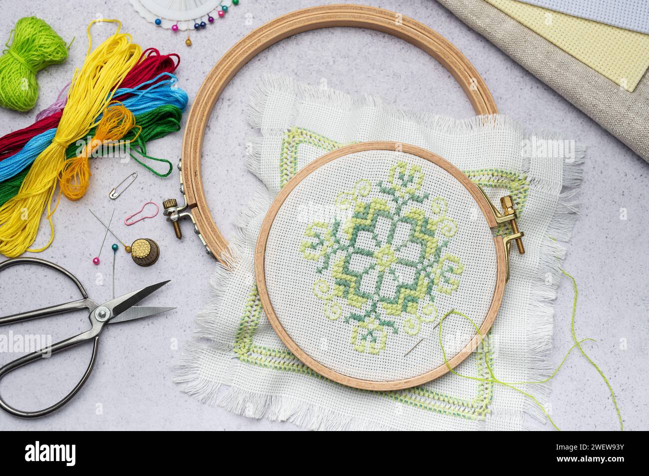 Embroidery with colored threads and various sewing accessories on the table Stock Photo
