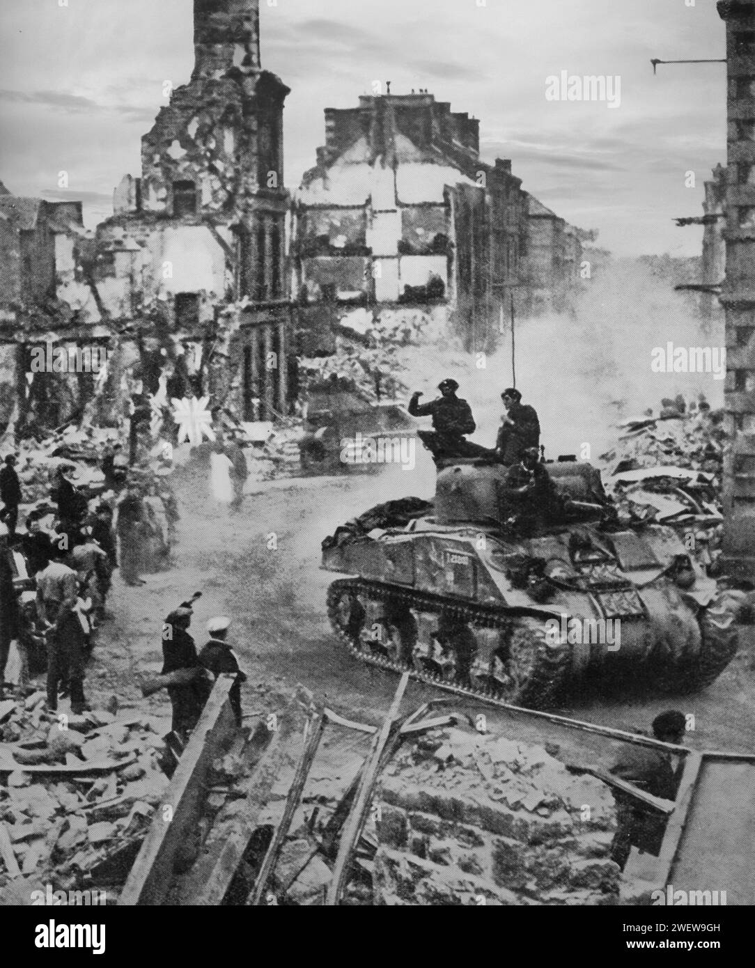 Tanks pass through the ruins of the Normandy town of Flers on the 17th August 1944, part of the allied invasion of Europe during the Second World War. Stock Photo