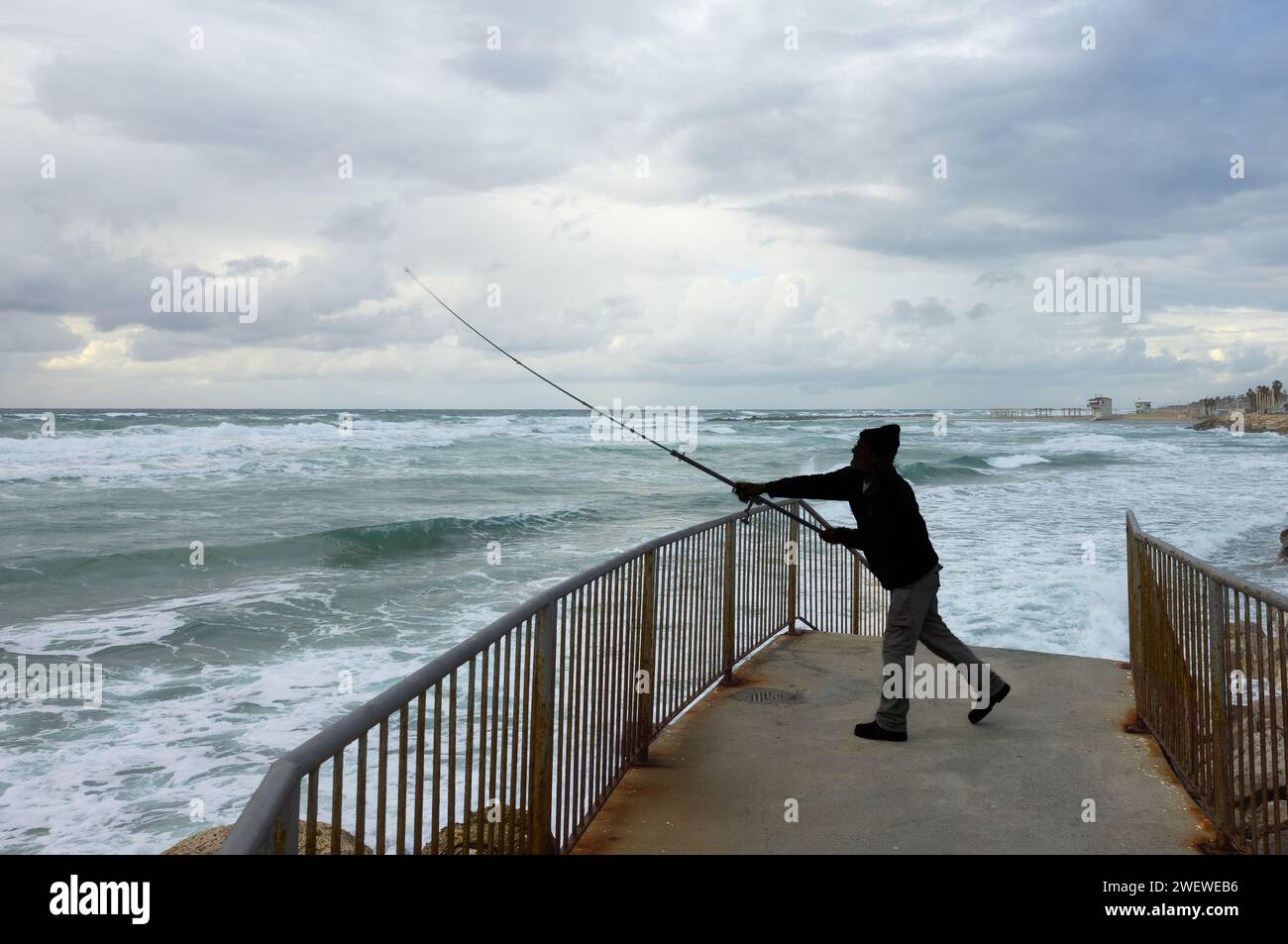 fisherman catches fish at sea in stormy weather Stock Photo