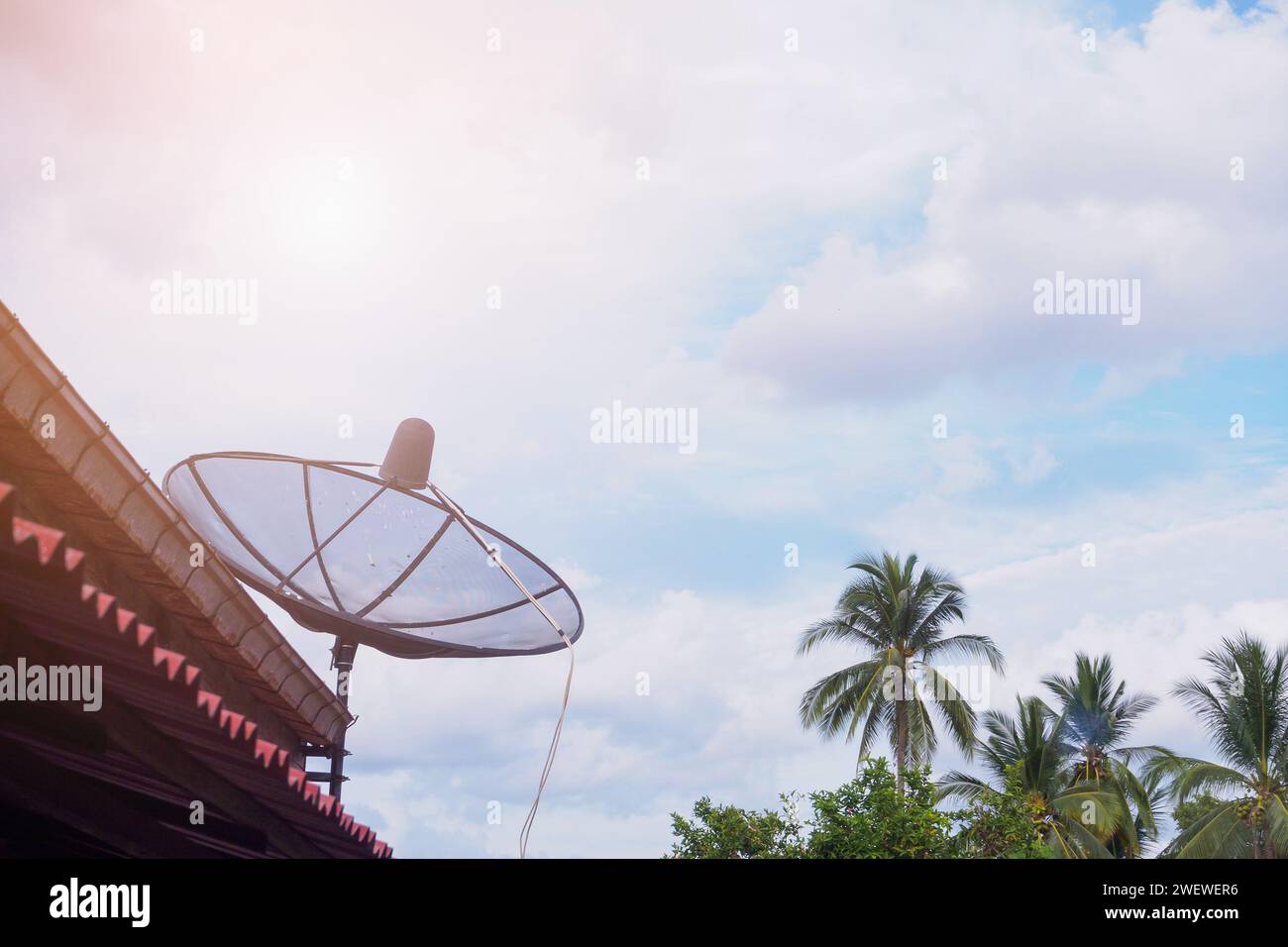 TV Satellite dish antenna on the roof house in rural with sky clouds