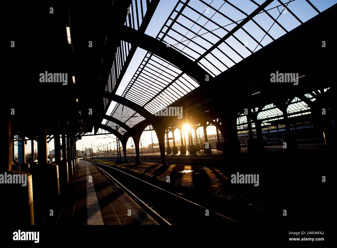 Oldenburg, Germany. 27th Jan, 2024. The sun rises in the morning behind the historic track hall at the main station. Deutsche Bahn and the train drivers' union GDL held talks on Saturday night during the ongoing strike. Deutsche Presse-Agentur learned this from negotiating circles. Credit: Hauke-Christian Dittrich/dpa/Alamy Live News Stock Photo