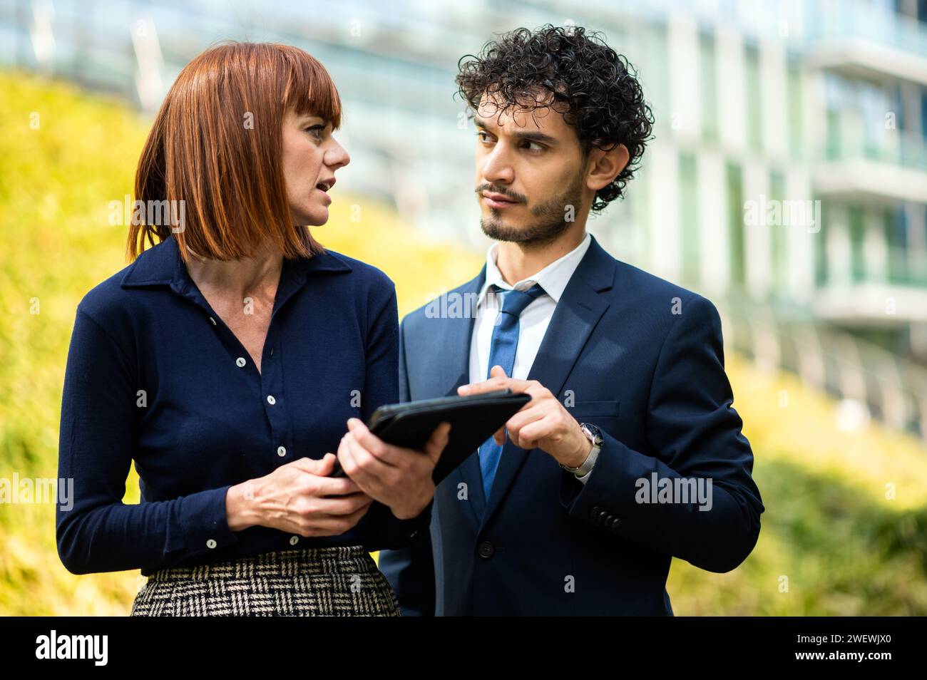 Couple of business people using a tablet outdoor Stock Photo