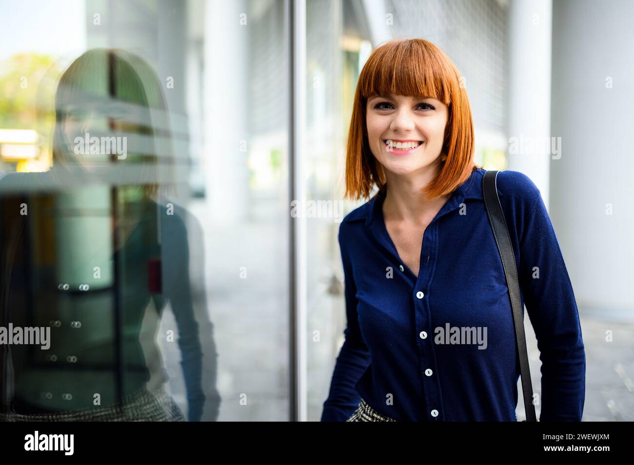 Confident young redhead female manager outdoor in a modern urban setting Stock Photo