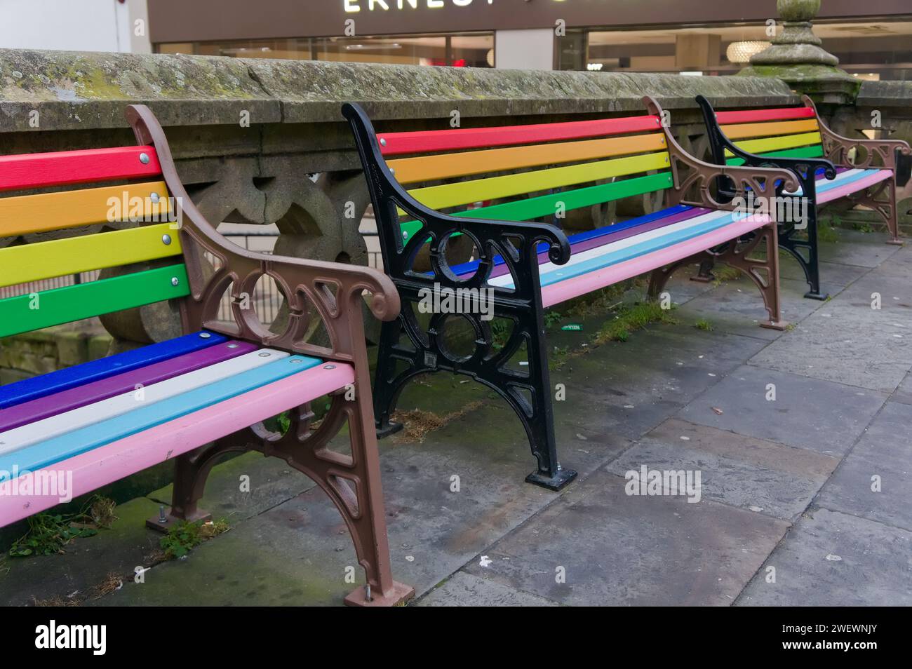 rainbow-coloured wooden seating by the river Witham in Lincoln city centre Stock Photo