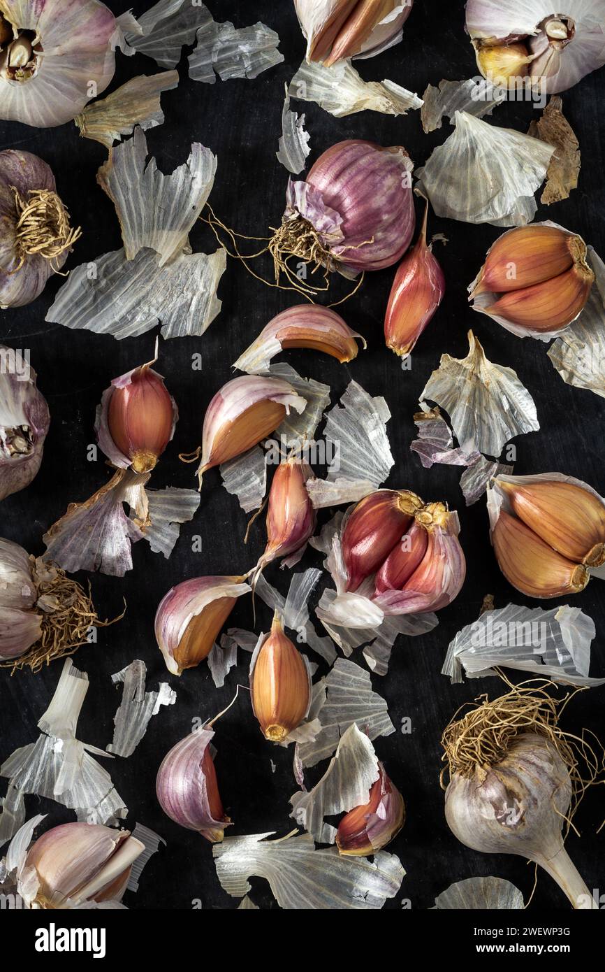 Fresh garlic bulbs and cloves grouped on black background. Flat lay ...