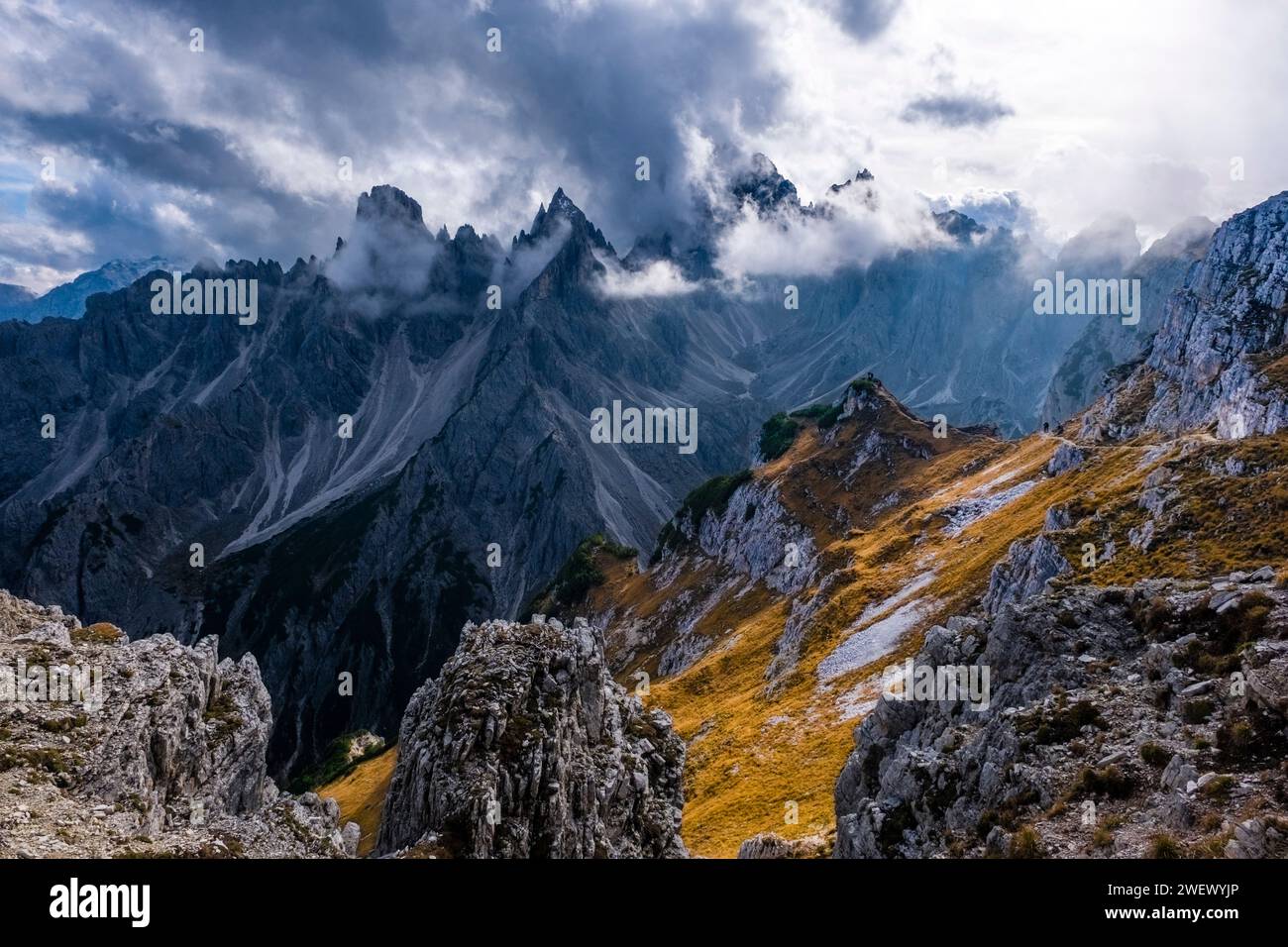 The rocky summits of the rock formation Cadini di Misurina in Tre Cime National Park, partially shrouded in clouds, in autumn. Stock Photo
